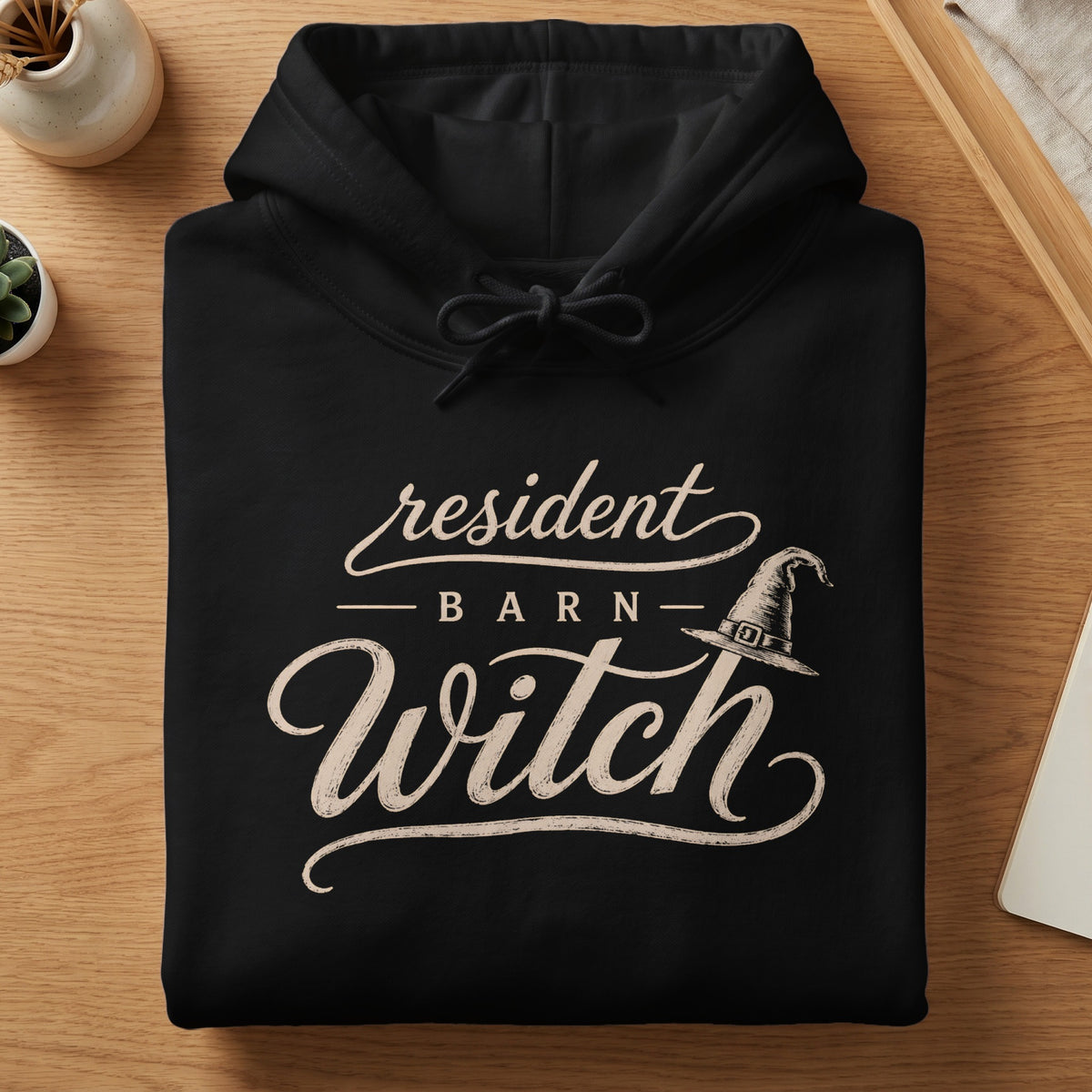 Black hoodie with "Resident Barn Witch" text and witch hat graphic.