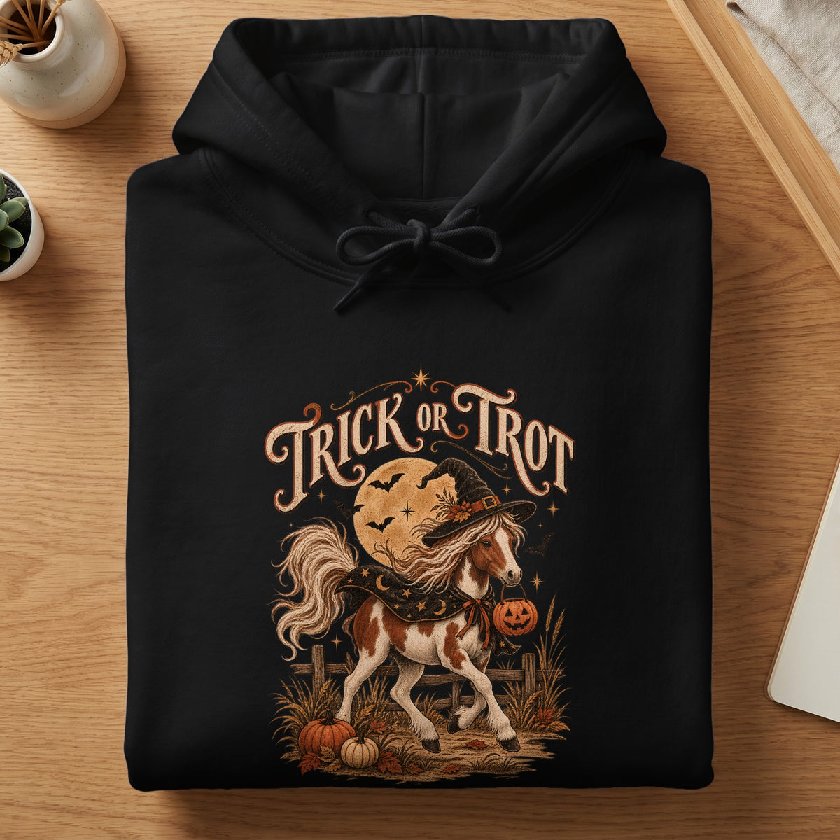 Black hoodie with "Trick or Trot" text and a horse in a witch hat.