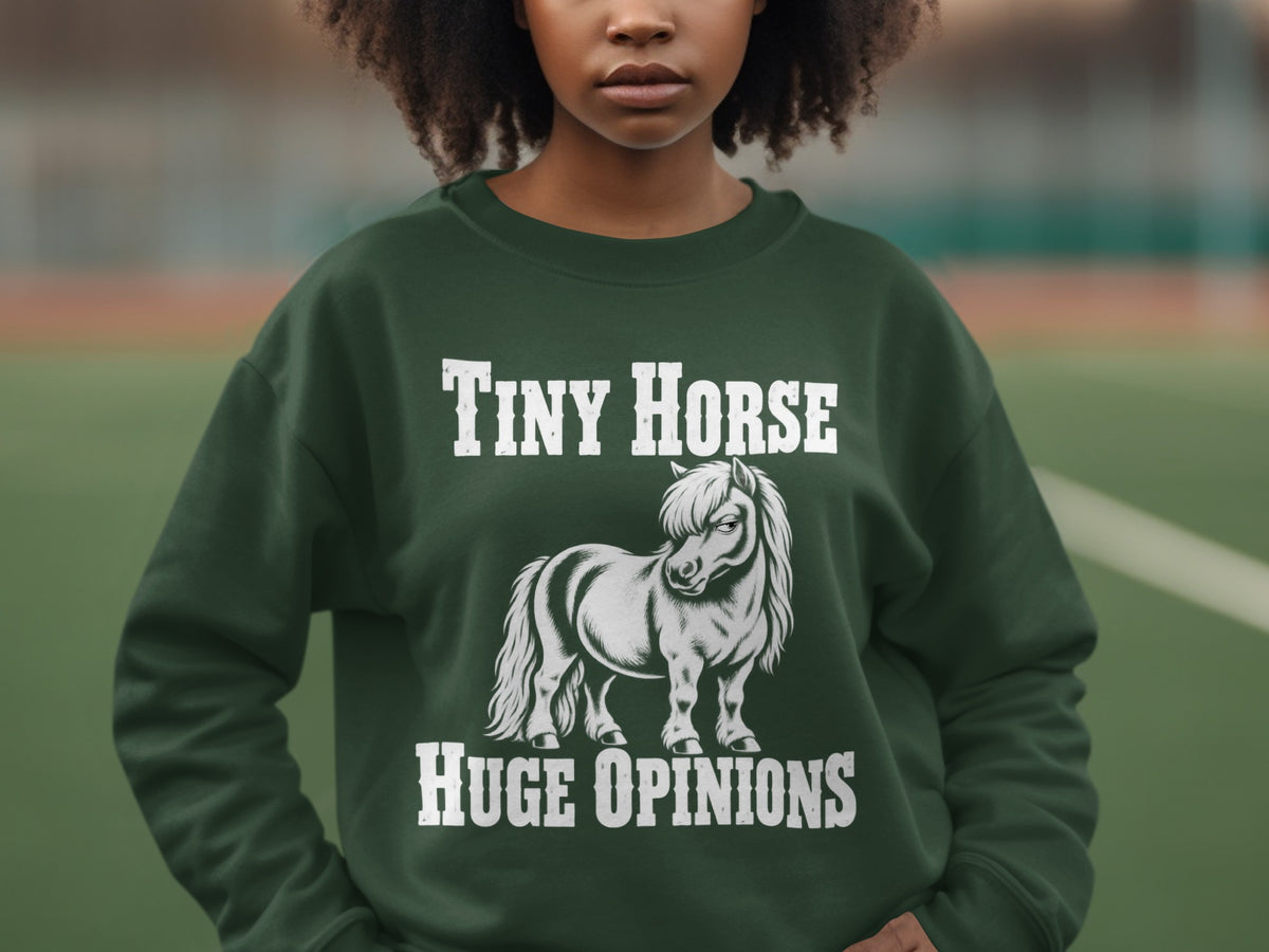 A dark green sweatshirt with white text reading Tiny Horse Huge Opinions above and below a pony illustration.