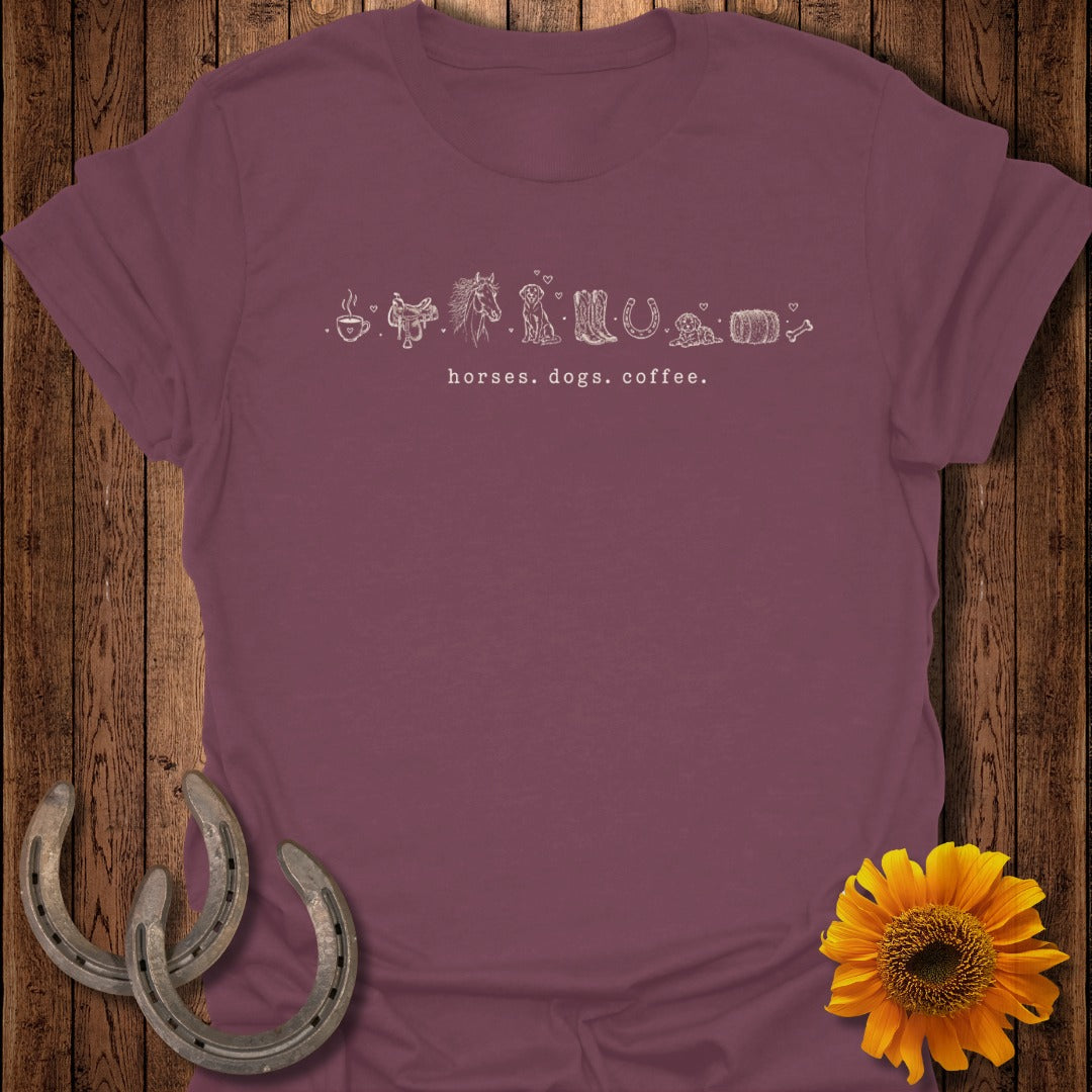 Maroon t-shirt with line art of horses, dogs, coffee cup, boots, and barrel.