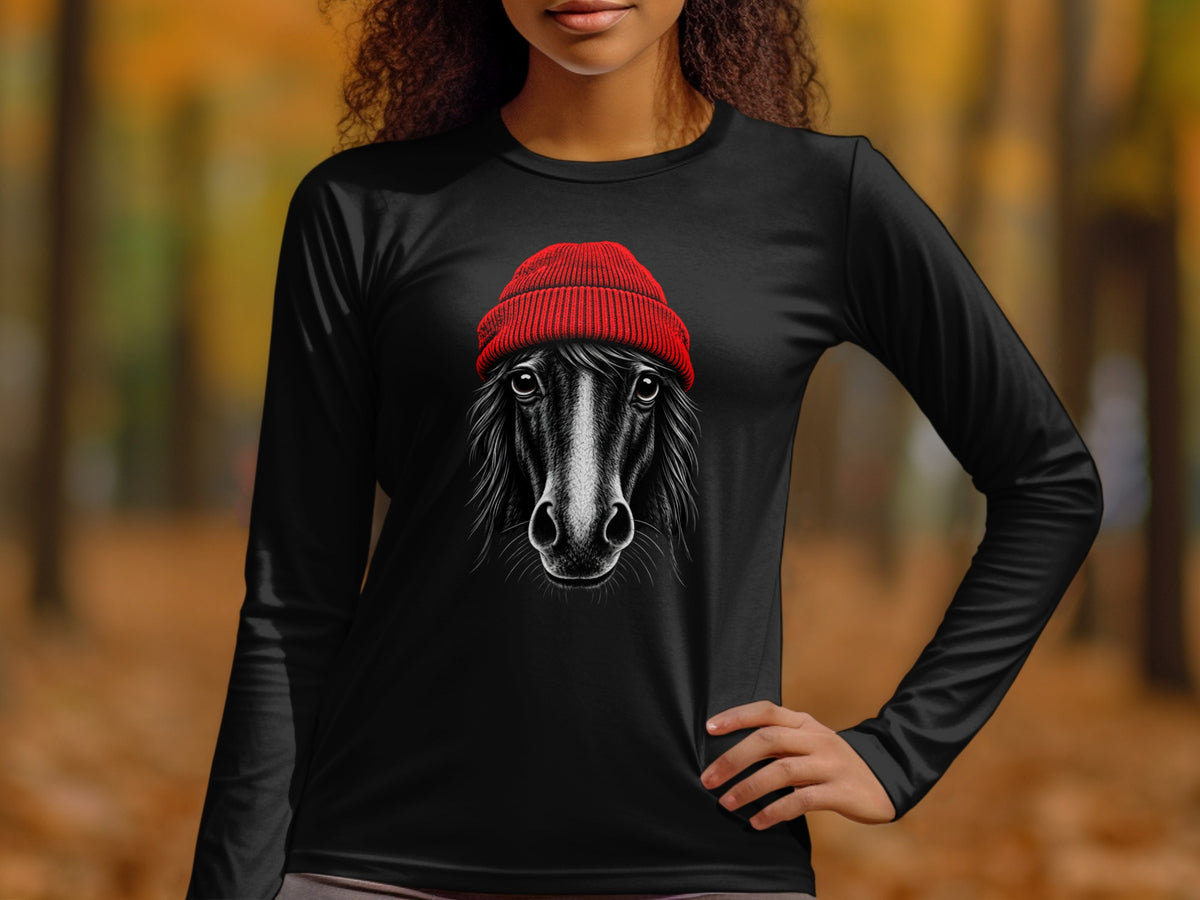 A woman wearing a black long-sleeve shirt with a graphic of a horse wearing a red beanie.