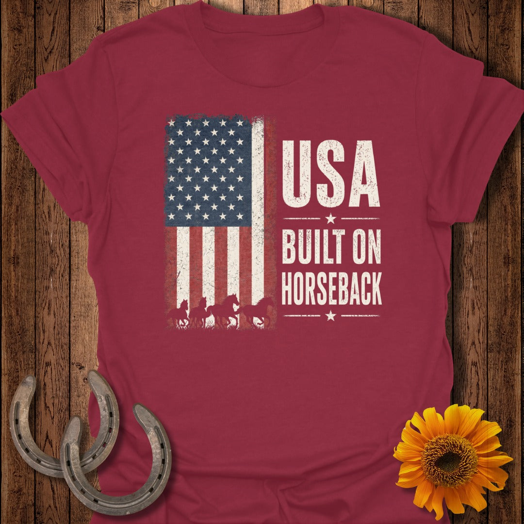 Red t-shirt with distressed USA flag and American horses graphic that reads "USA BUILT ON HORSEBACK".