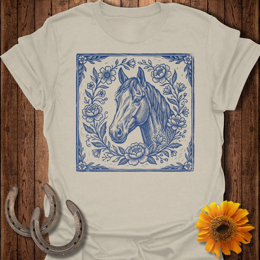 Blue floral illustration of a horse's head on a tan t-shirt.
