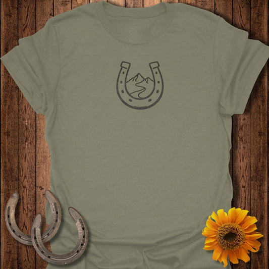 Olive green t-shirt with horseshoe, mountain, and river graphic.