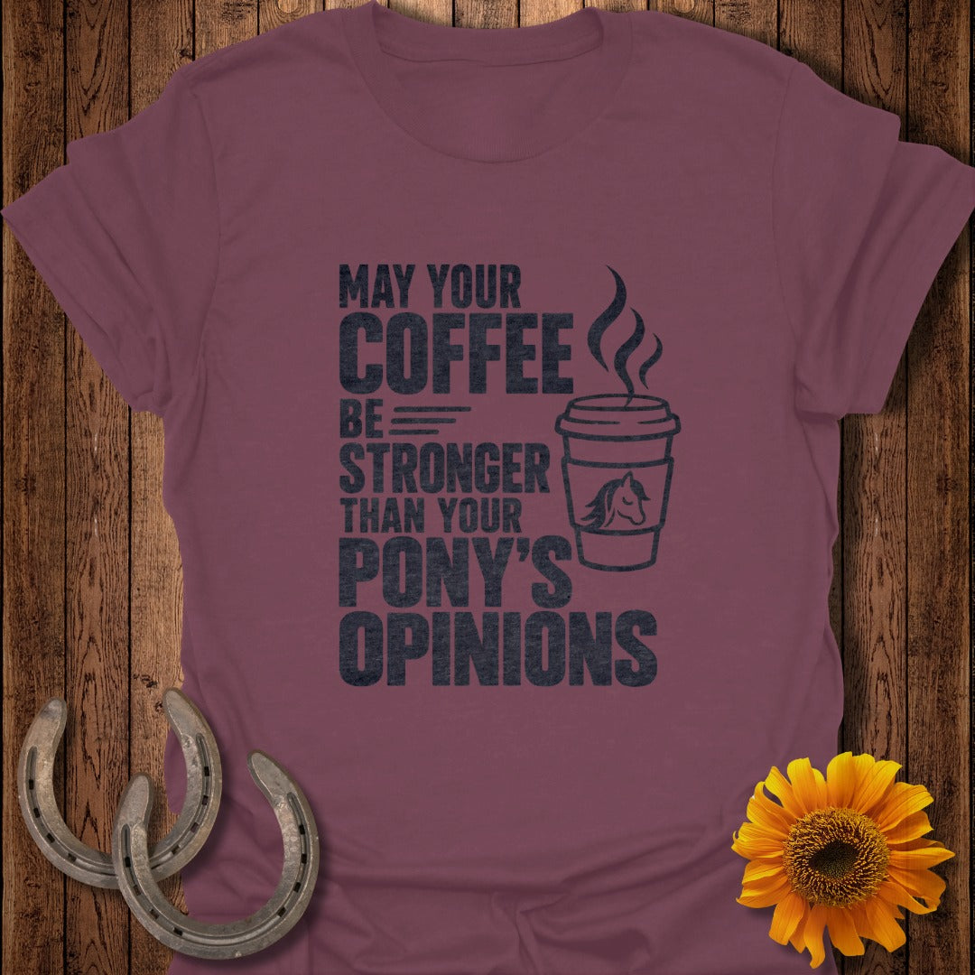 A maroon t-shirt with black text reading "May Your Coffee Be Stronger Than Your Pony's Opinions" next to a coffee cup illustration.
