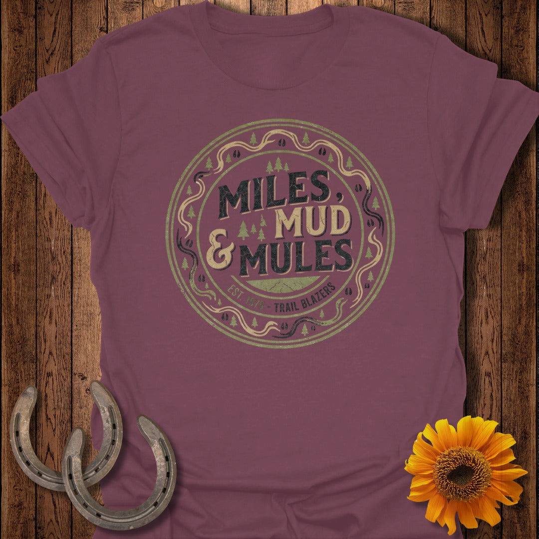 Burgundy t-shirt with "Miles & Mud Trail Blazers" circular logo and graphic elements.