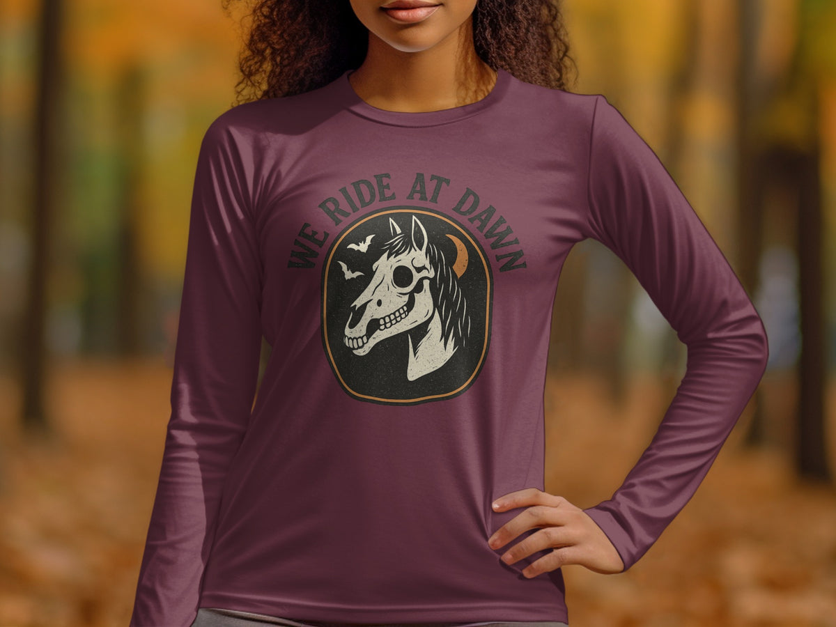 Long sleeve shirt with a horse skull graphic and "WE RIDE AT DAWN" text.