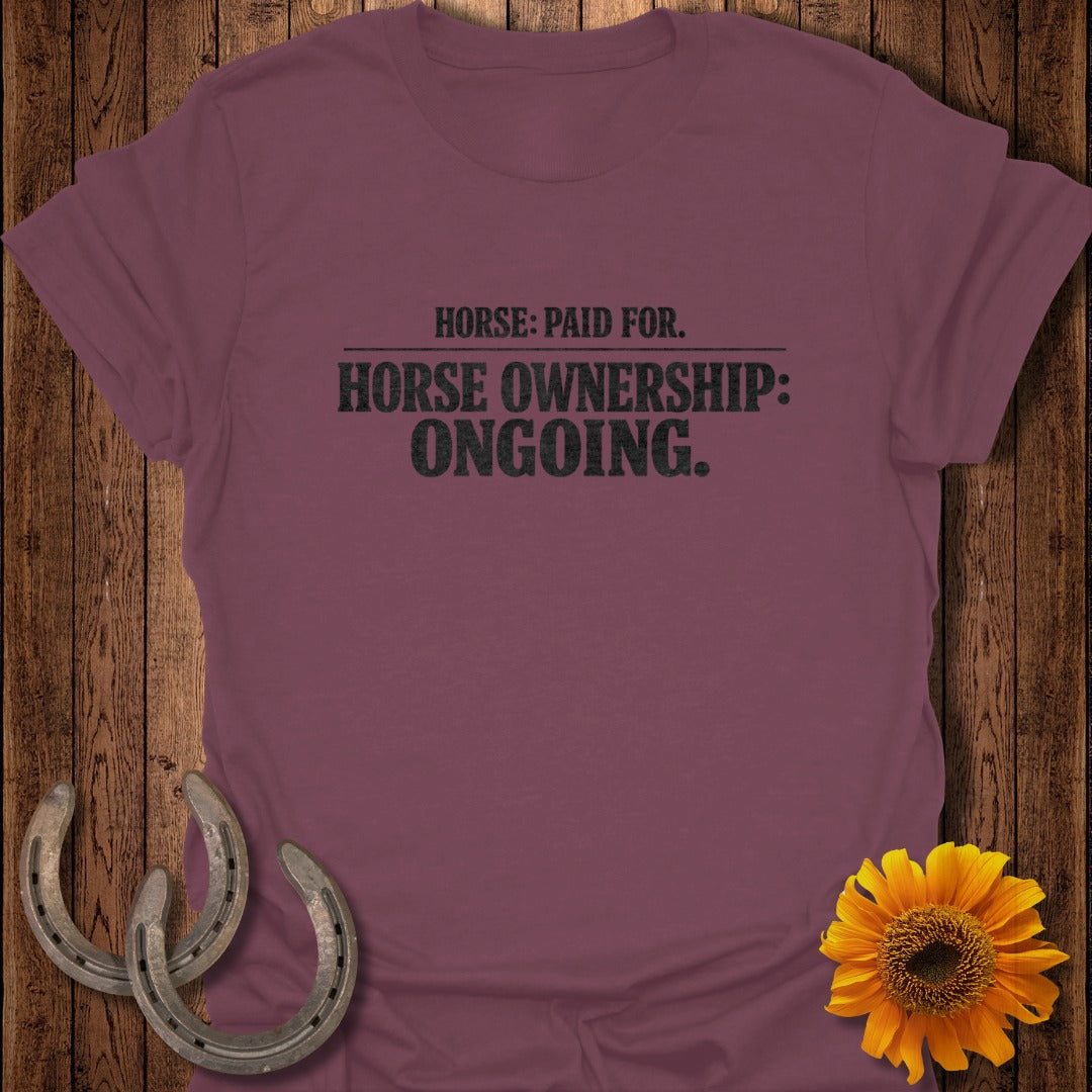 Burgundy t-shirt with black text reading "HORSE: PAID FOR. HORSE OWNERSHIP: ONGOING."