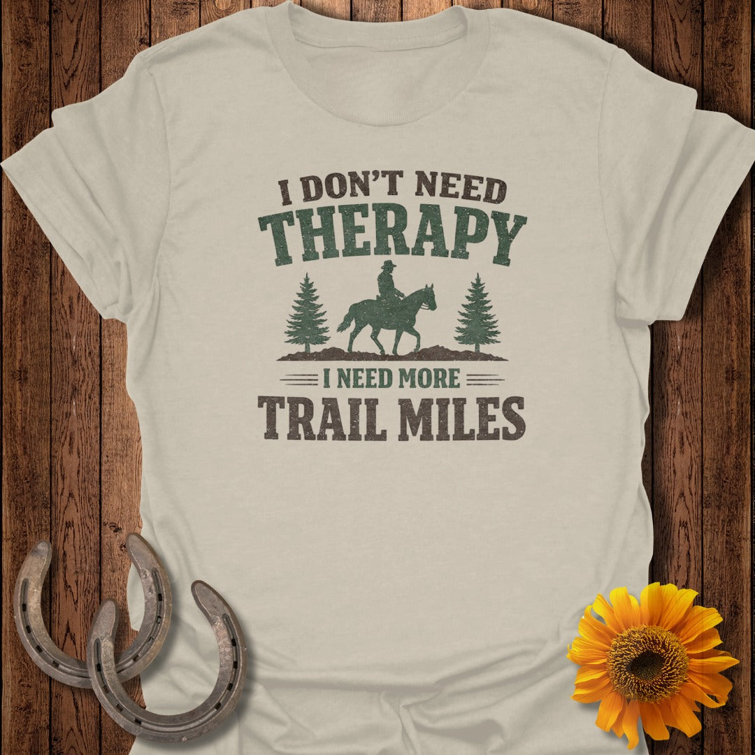 Light beige t-shirt with "I Don't Need Therapy I Need More Trail Miles" text and equestrian graphic.