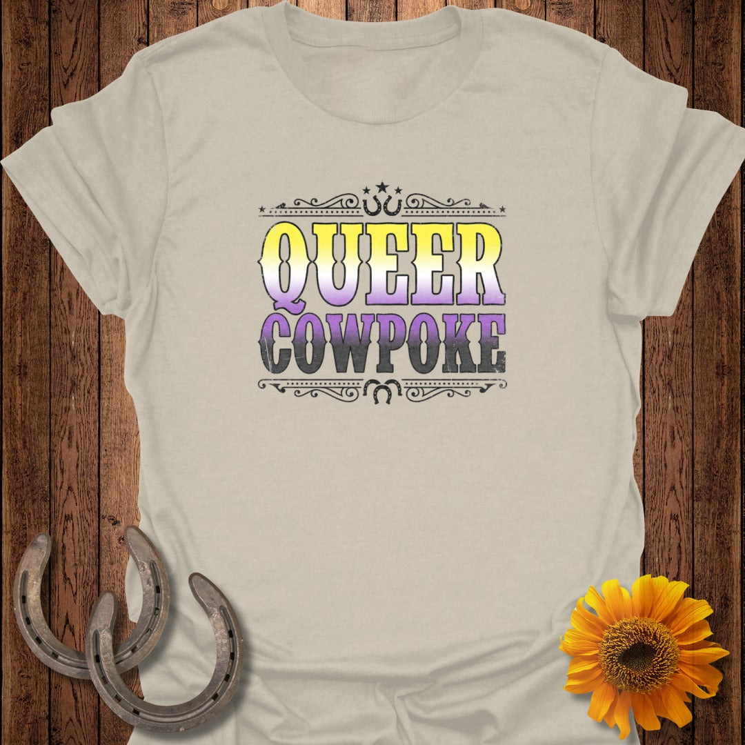 Queer Cowpoke text on a tan t-shirt with horseshoes and sunflower.