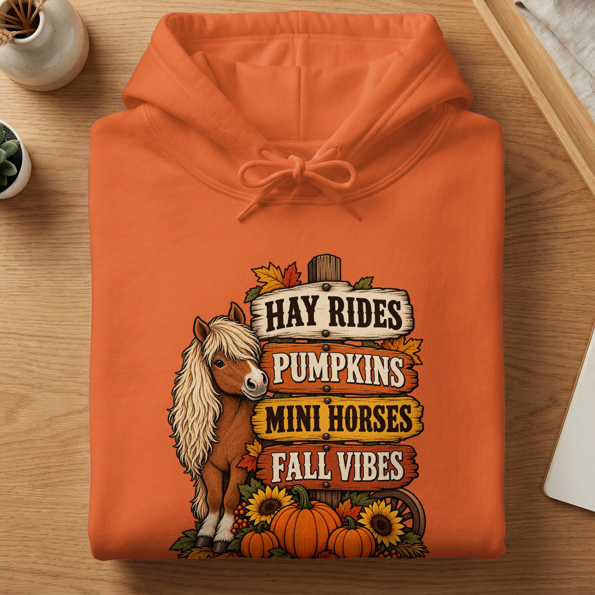 Orange hoodie with a graphic of a mini horse, pumpkins, and autumn vibes signs.