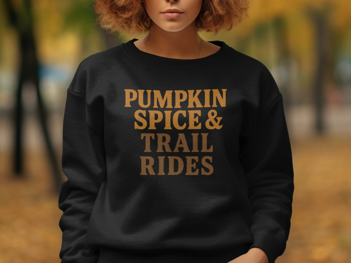 Black sweatshirt with "Pumpkin Spice & Trail Rides" text in gold lettering.
