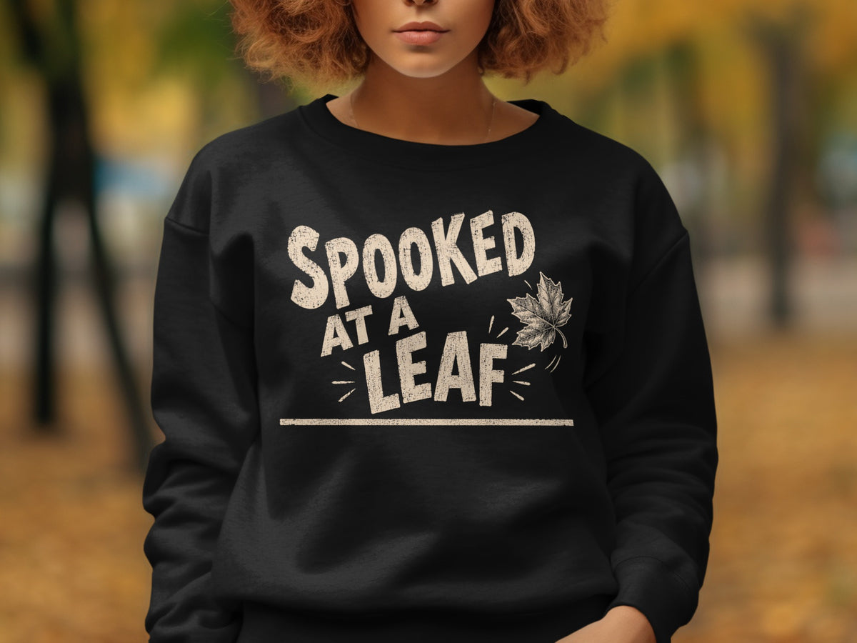 Black sweatshirt with "Spooked At A Leaf" text and a leaf graphic.