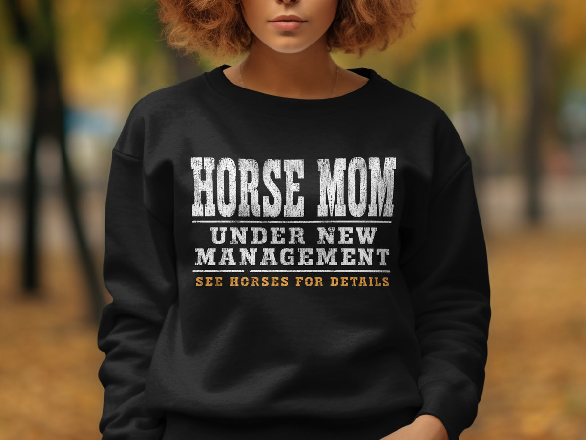 Black sweatshirt with white text: "HORSE MOM UNDER NEW MANAGEMENT SEE HORSES FOR DETAILS".