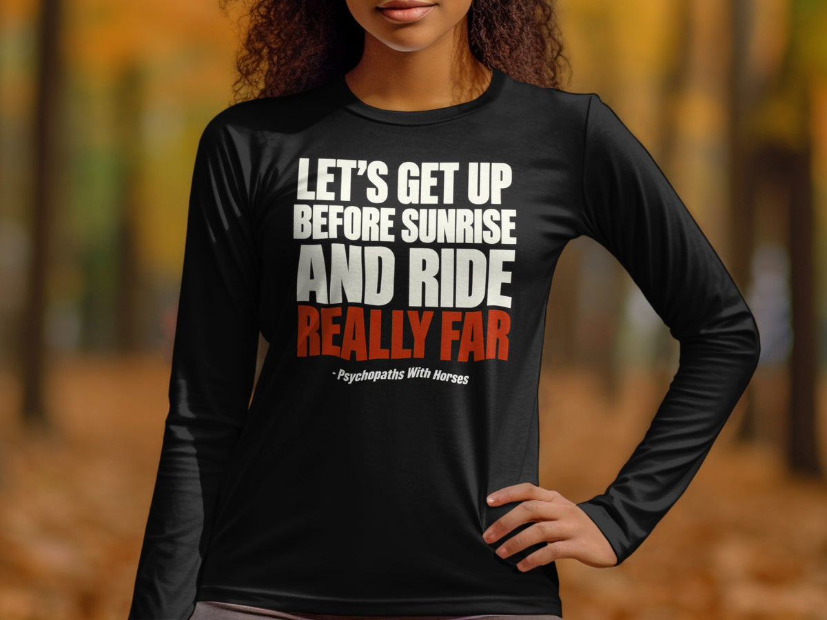 A person wearing a black long-sleeve shirt with white and red text reading Let's Get Up Before Sunrise And Ride Really Far and Psychopaths With Horses.