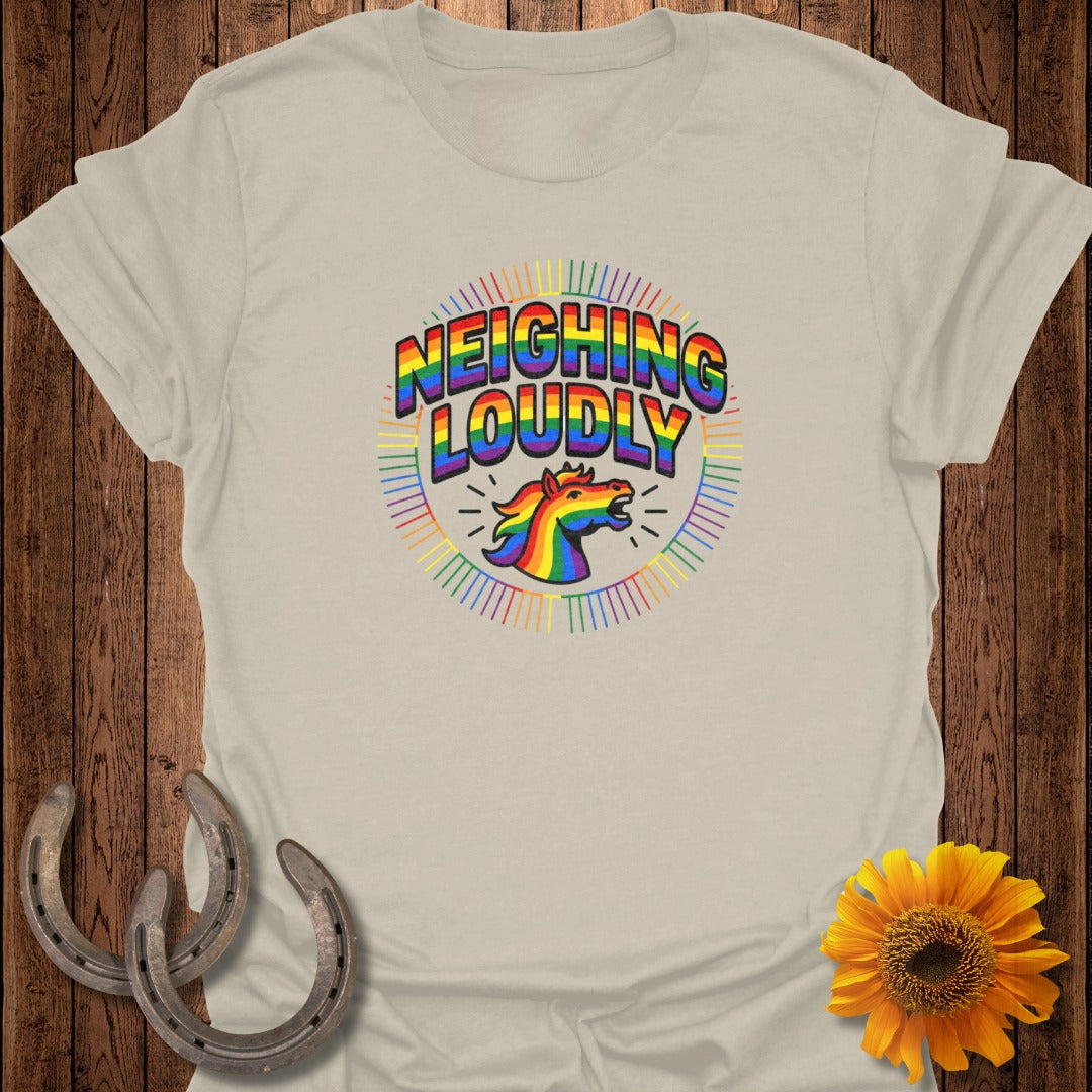 Rainbow unicorn head and "NEIGHING LOUDLY" text on a beige t-shirt.