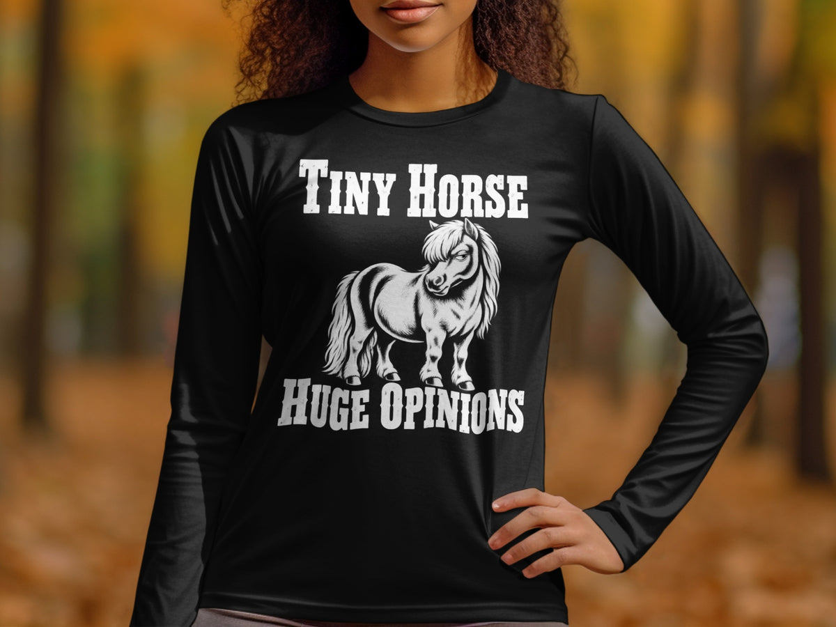 A woman wearing a black long-sleeve shirt with a graphic of a pony and the text Tiny Horse Huge Opinions.