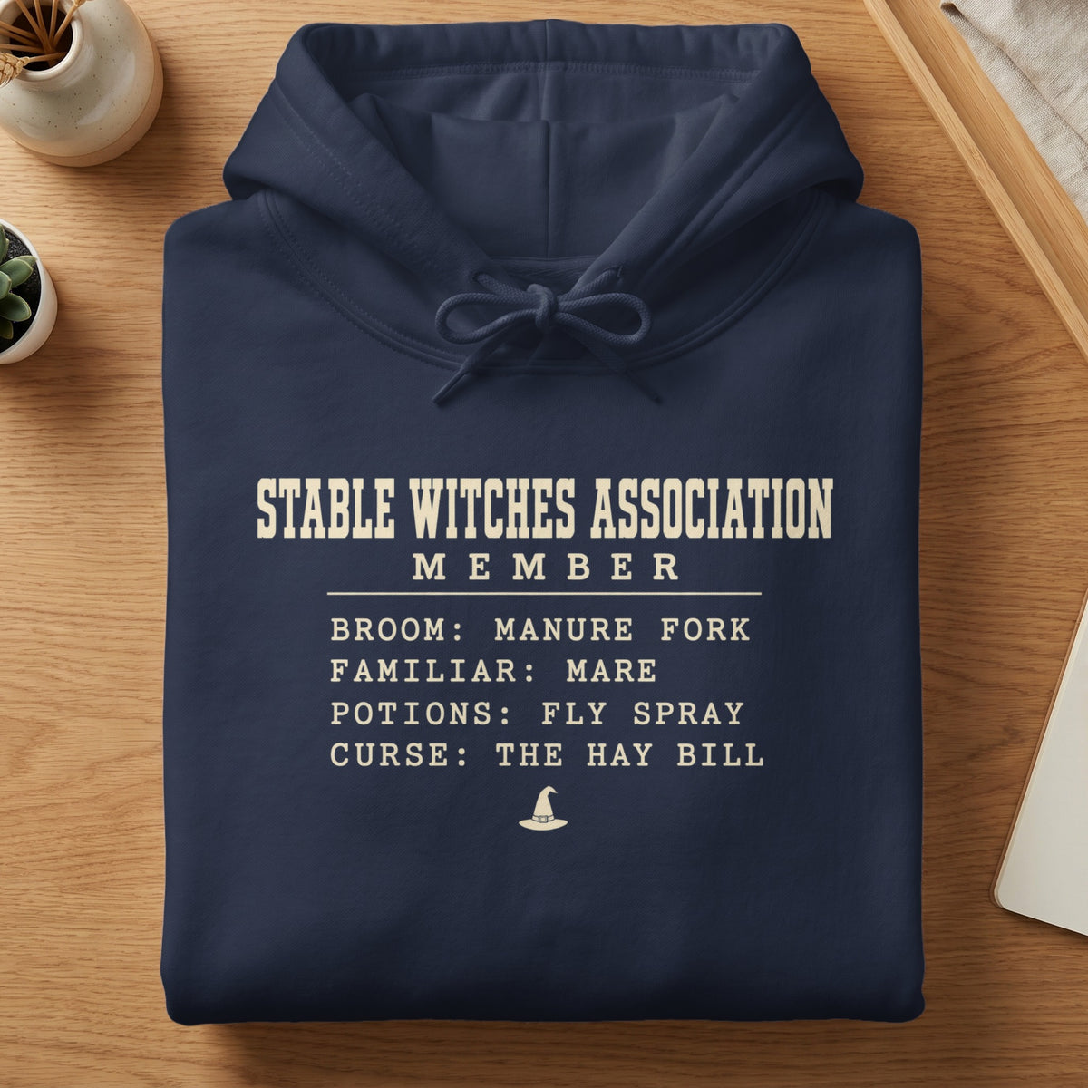 Navy hoodie with "Stable Witches Association Member" text and lists.