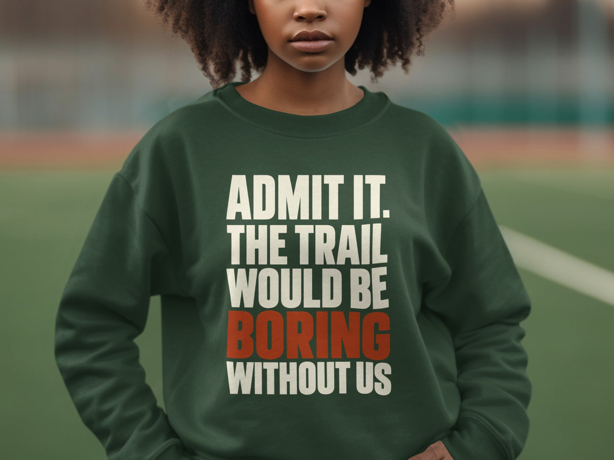 A person wearing a dark green crewneck sweatshirt featuring white and orange text.