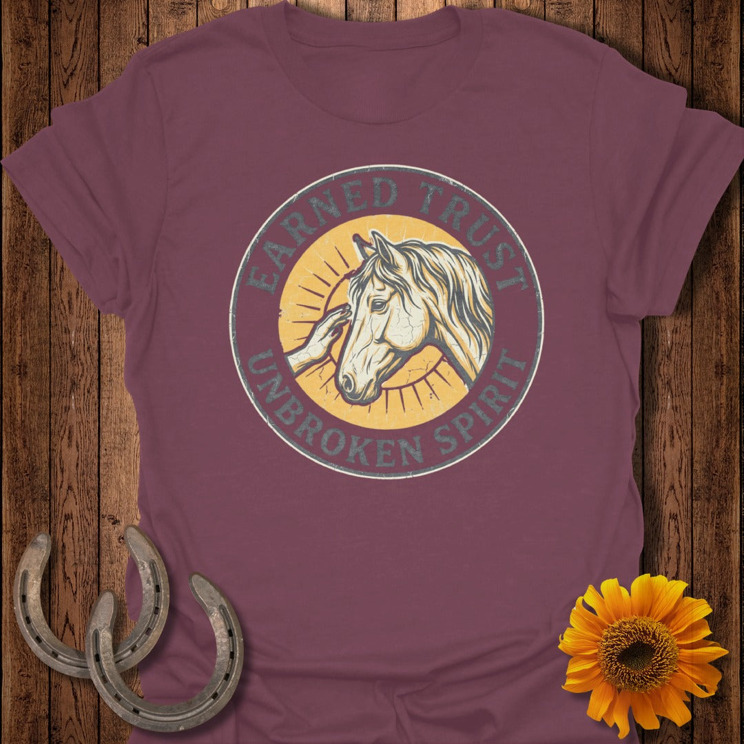 T-shirt with horse and rider graphic, "Earned Trust Unbroken Spirit" text.