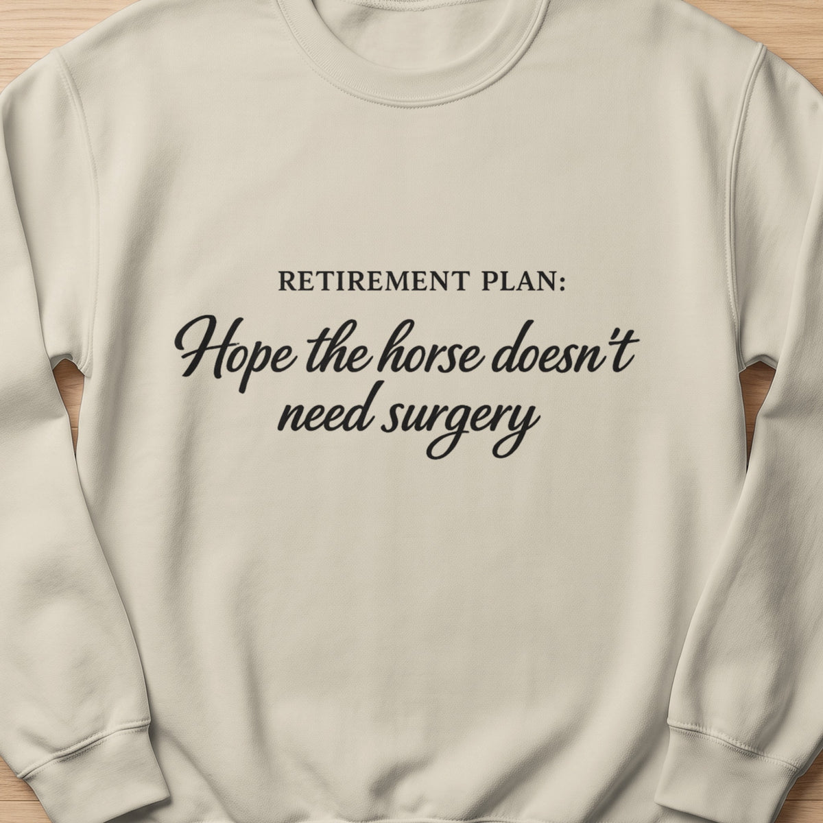Light cream sweatshirt with "Retirement Plan: Hope the horse doesn't need surgery" text.