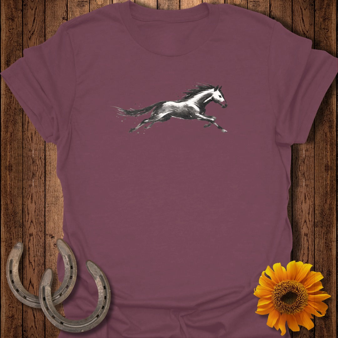 T-shirt with a black and white watercolor galloping horse graphic and decorative horseshoes.