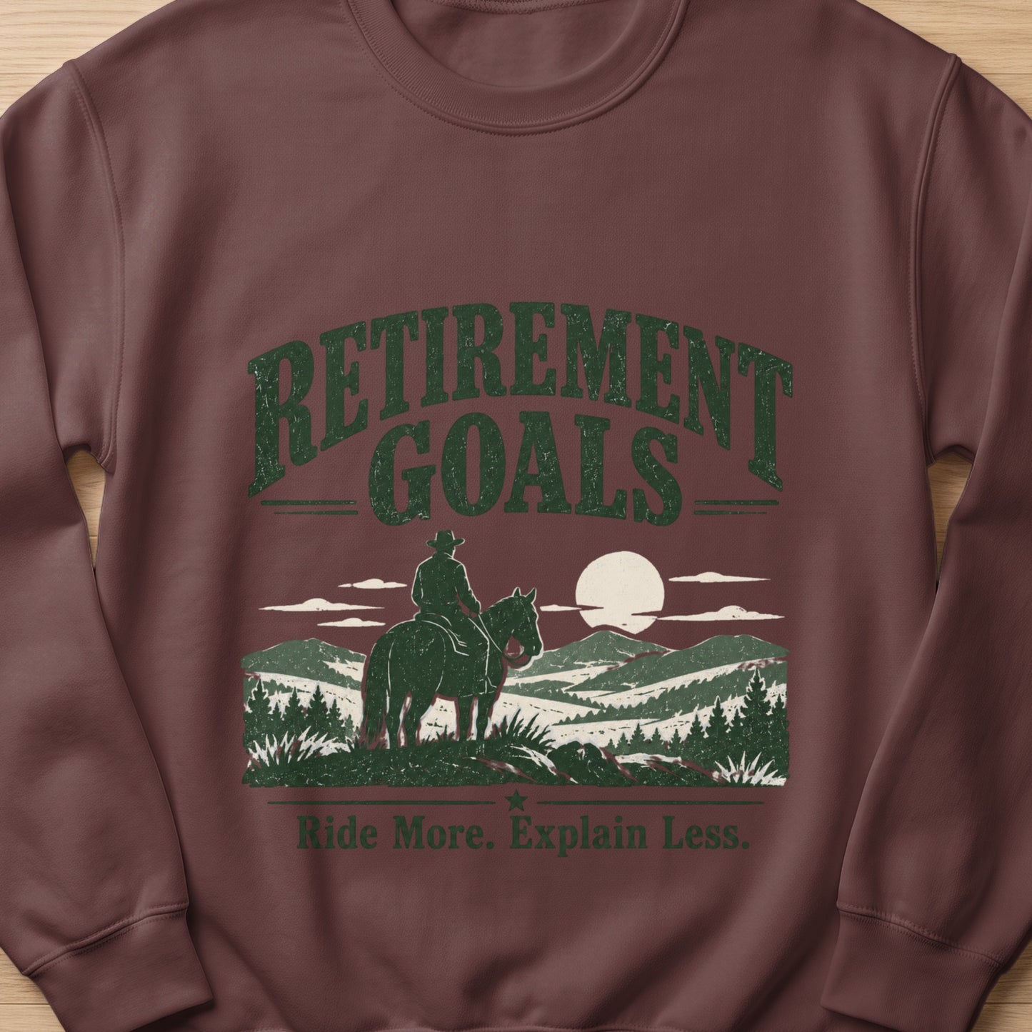 Brown sweatshirt with "Retirement Goals" and a cowboy on horseback.