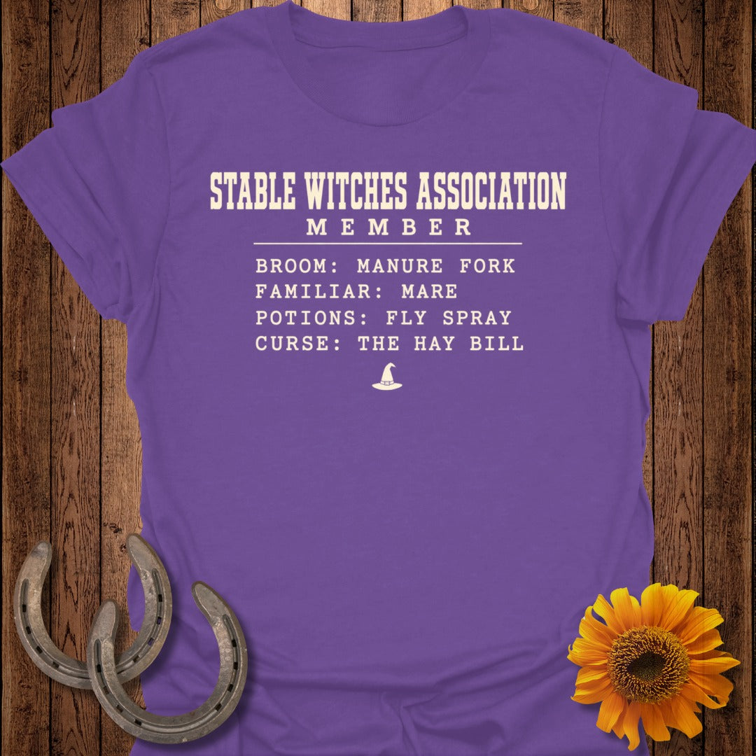 Purple t-shirt with "Stable Witches Association Member" text and equestrian-themed details.