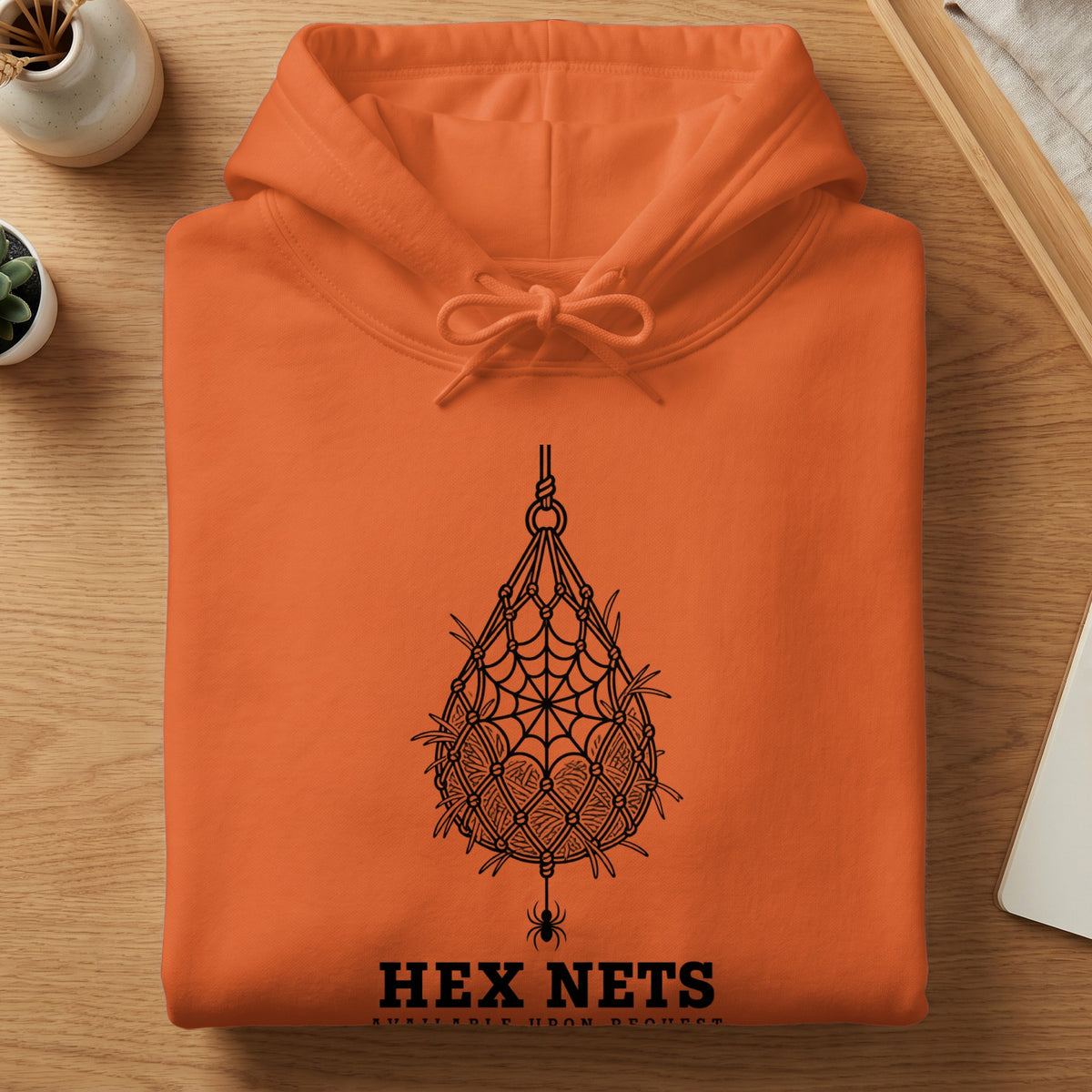 Orange hoodie with a black spiderweb and spider graphic, and the text "HEX NETS".