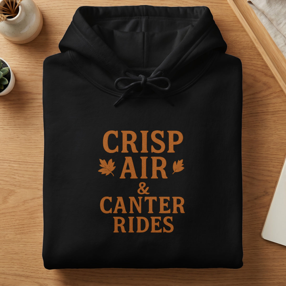Black hoodie with "Crisp Air & Canter Rides" text and autumn leaf graphics.