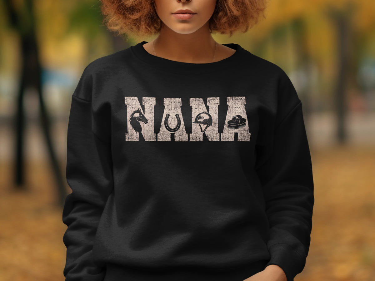 Black sweatshirt with "NANA" text and equestrian icons: horse, horseshoe, helmet, brush.