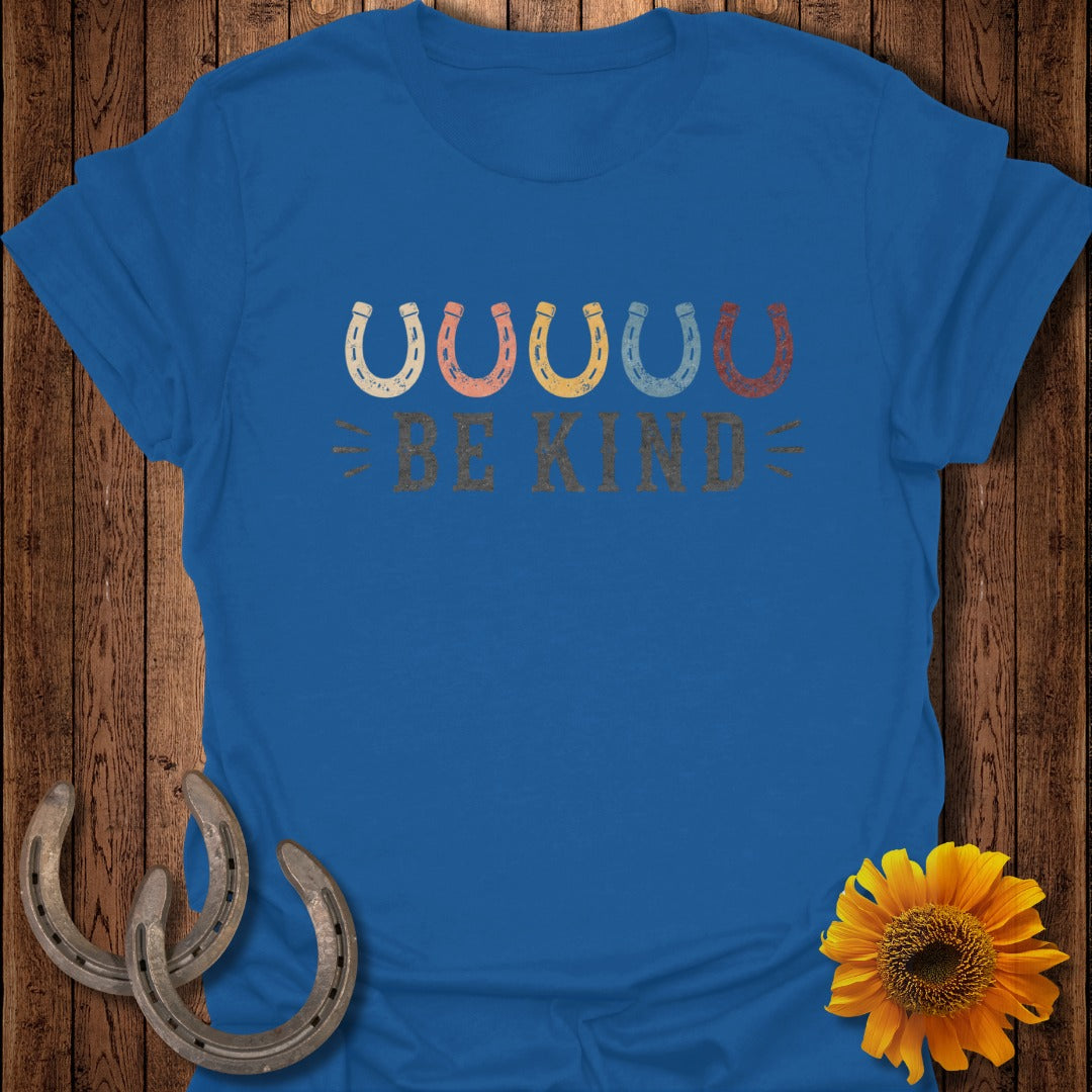 Blue t-shirt with colorful horseshoes and "BE KIND" text.