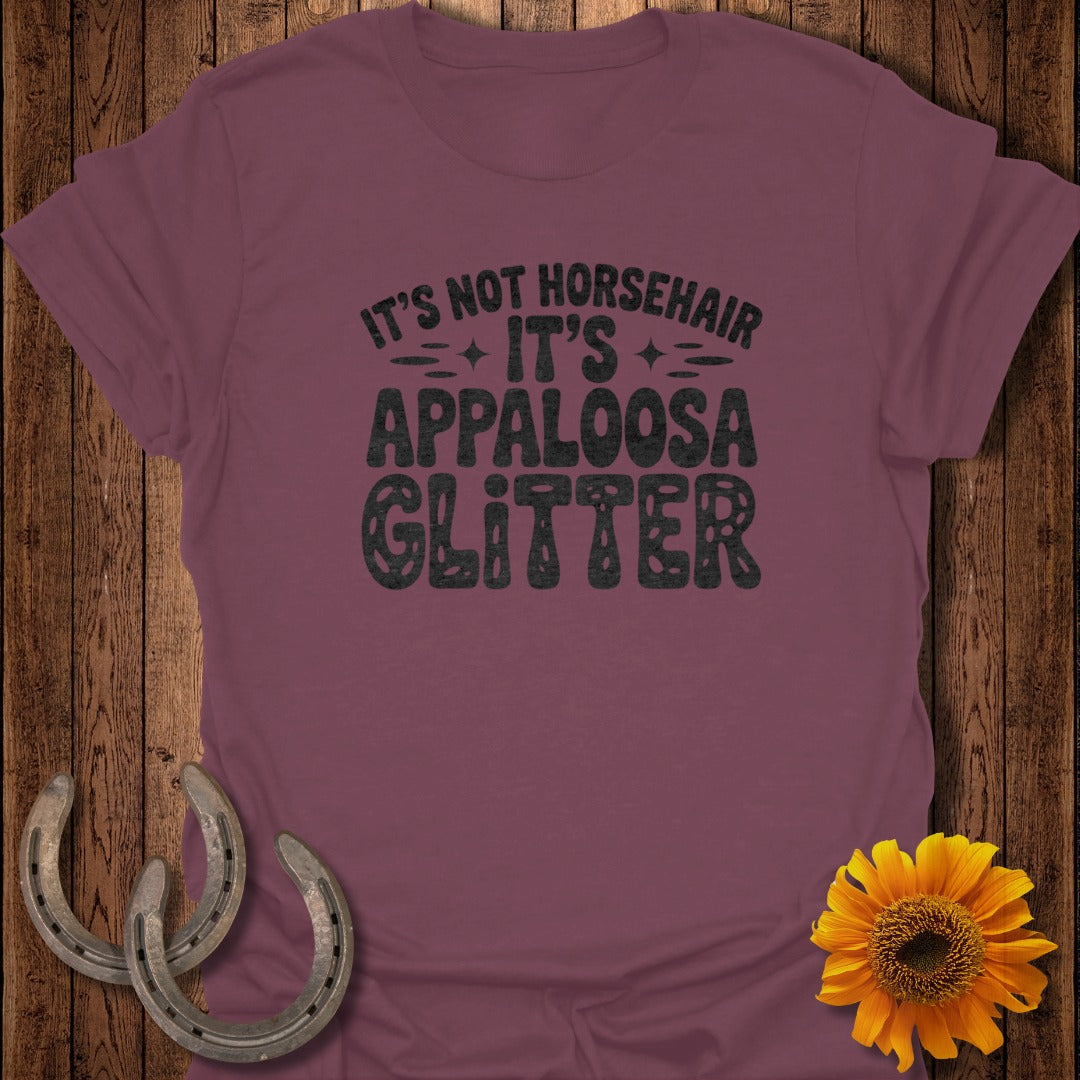 Burgundy t-shirt with "It's Not Horsehair, It's Appaloosa Glitter" text and two horseshoes.
