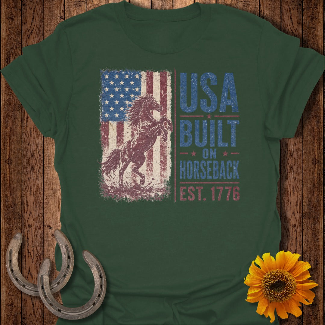 Green t-shirt with distressed USA flag, rearing horse, and text "USA BUILT ON HORSEBACK EST. 1776".