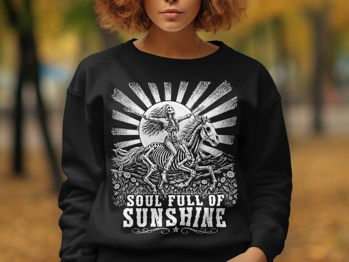 Black sweatshirt with skeleton riding horse, mountains, flowers, and "Soul Full of Sunshine" text.