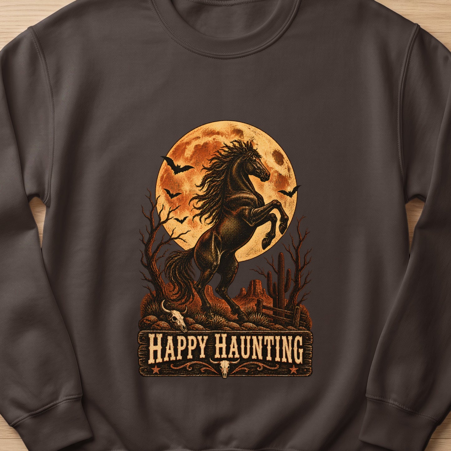 Dark horse rearing before a moon with bats and desert landscape text "Happy Haunting".