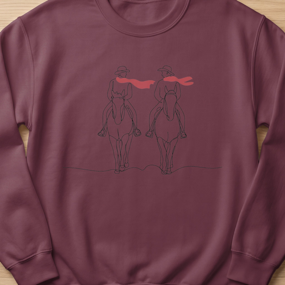 Line art of two people on horseback wearing hats and red scarves.