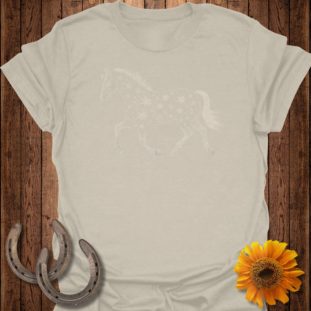 Light colored t-shirt with a white horse graphic adorned with stars and moons.