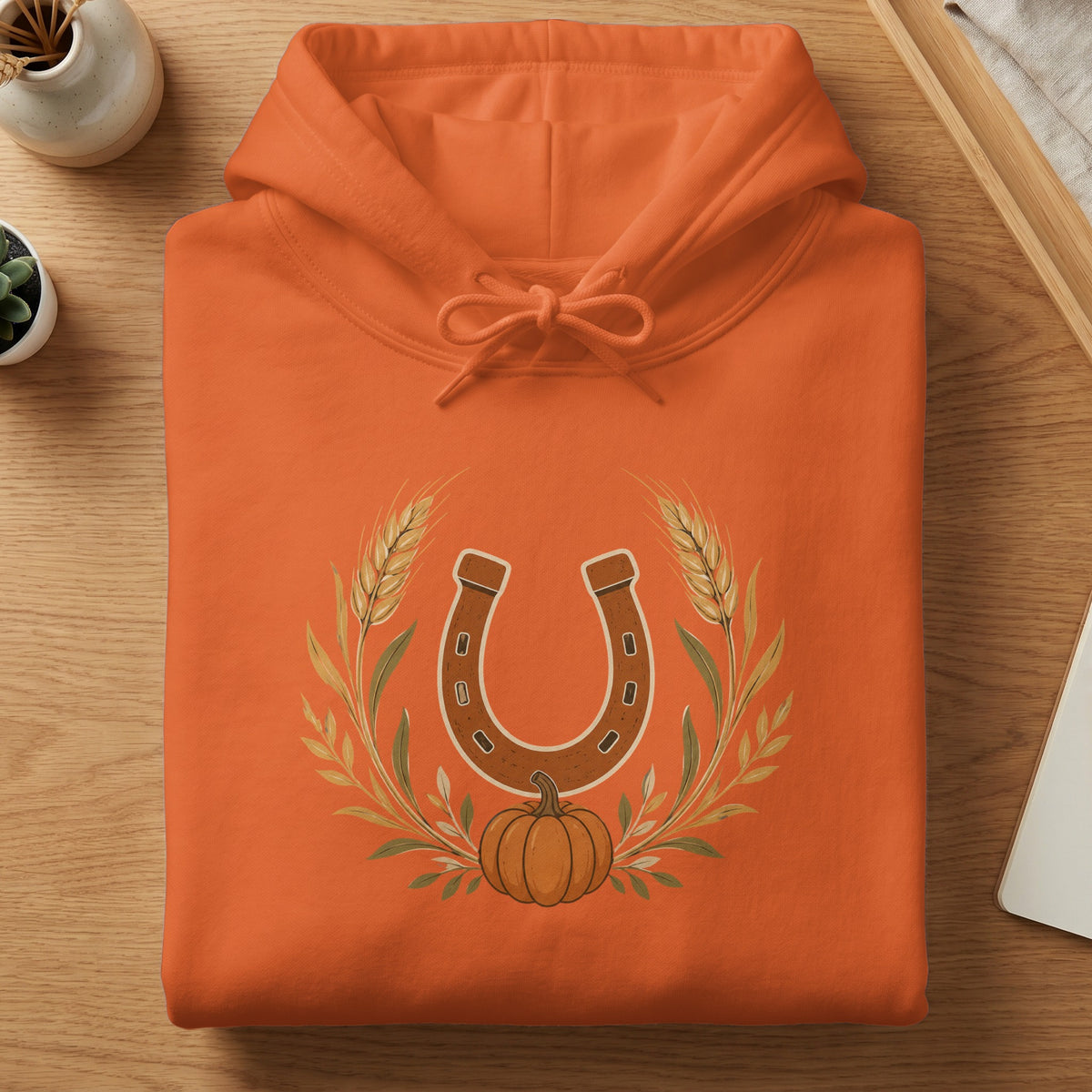 Orange hoodie with a horseshoe, pumpkin, and wheat graphic.