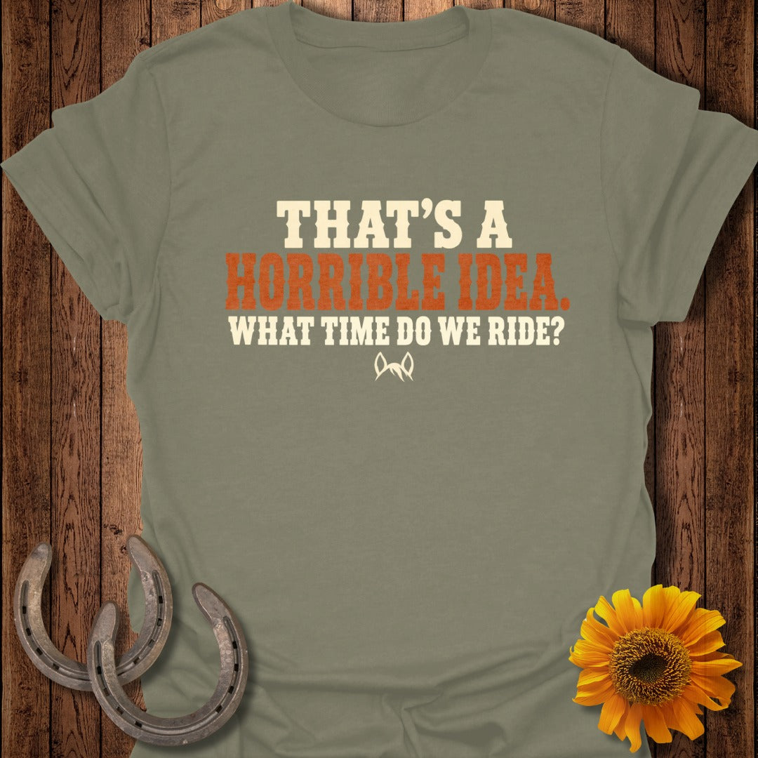 An olive green t-shirt with the text "THAT'S A HORRIBLE IDEA. WHAT TIME DO WE RIDE?"