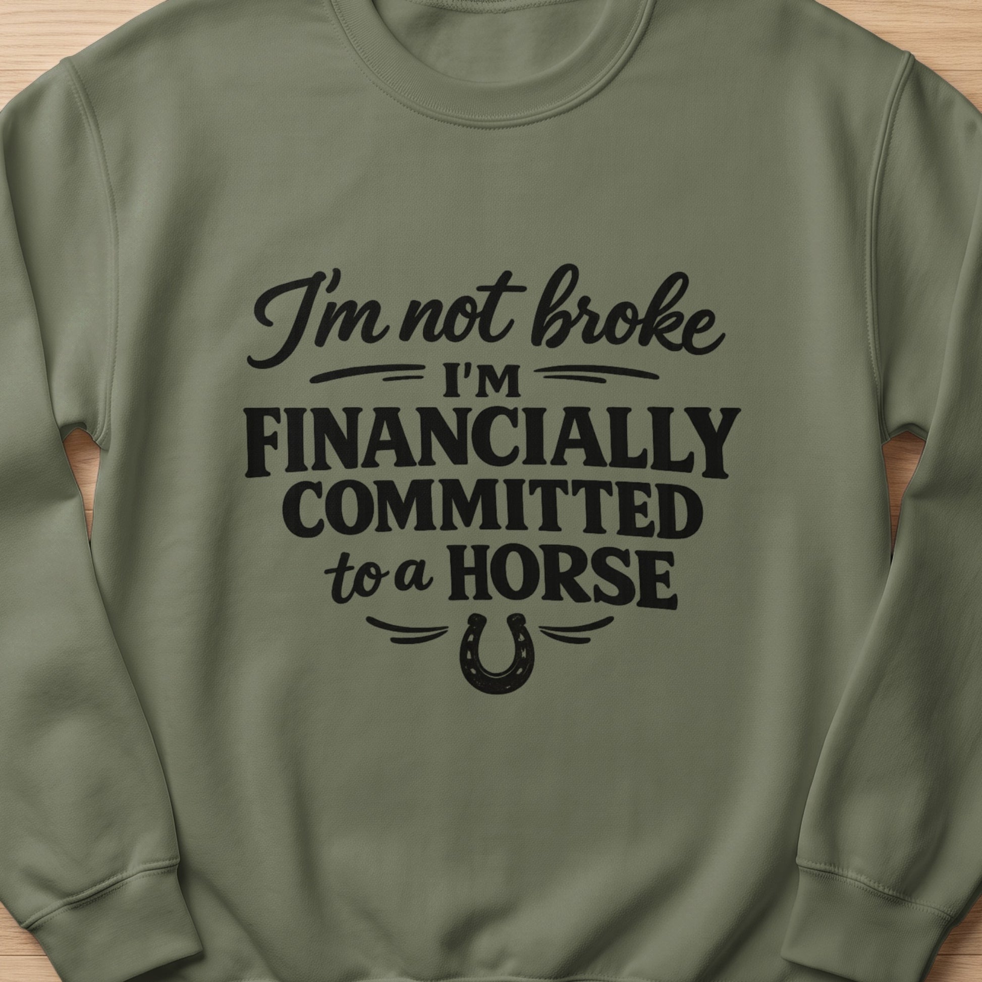 Olive green sweatshirt with text "I'm not broke I'm financially committed to a horse" and a horseshoe.