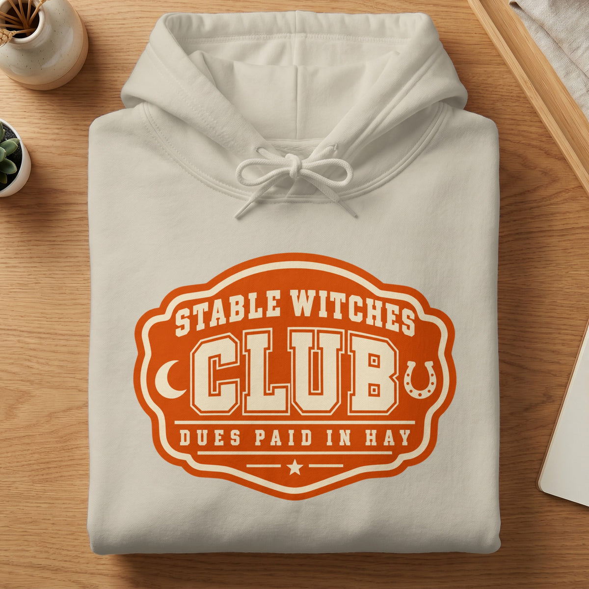Cream hoodie with "Stable Witches Club Dues Paid In Hay" graphic.