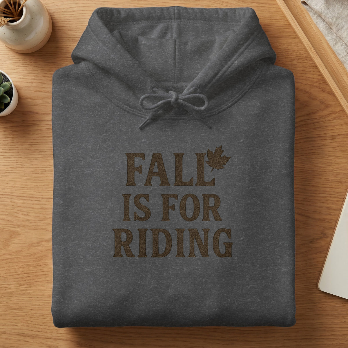 Charcoal grey hoodie with text "FALL IS FOR RIDING" and a maple leaf graphic.