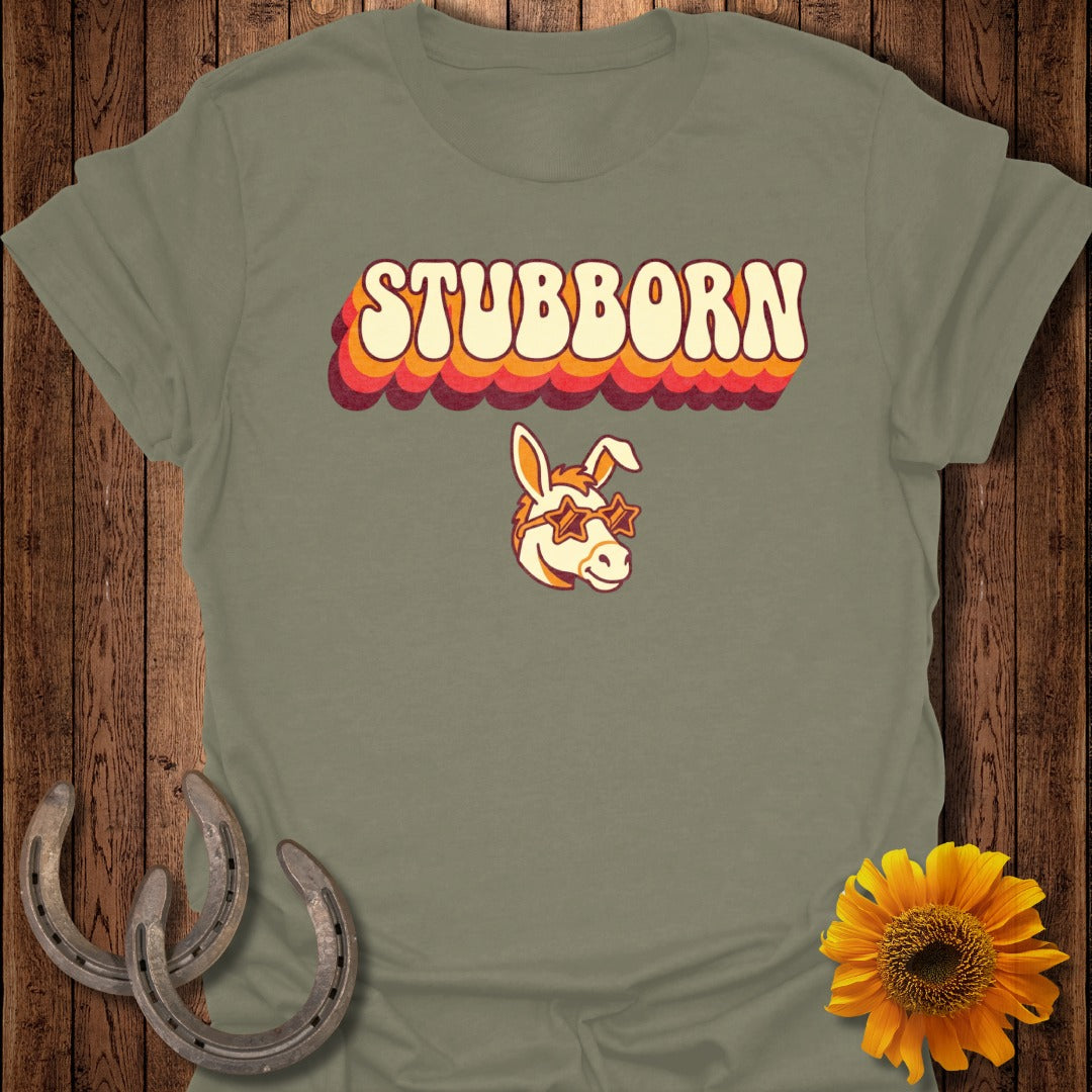Grey t-shirt with "STUBBORN" in retro font and a donkey wearing star sunglasses.