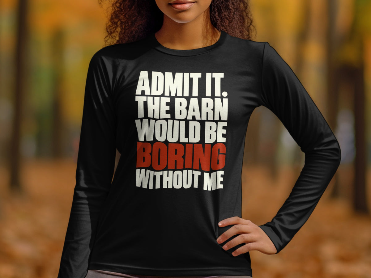 A person wearing a long-sleeved black shirt with white and red text stating, "Admit it, the barn would be boring without me."