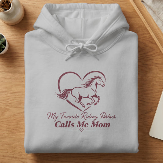 White hoodie with horse inside heart graphic and text "My Favorite Riding Partner Calls Me Mom."