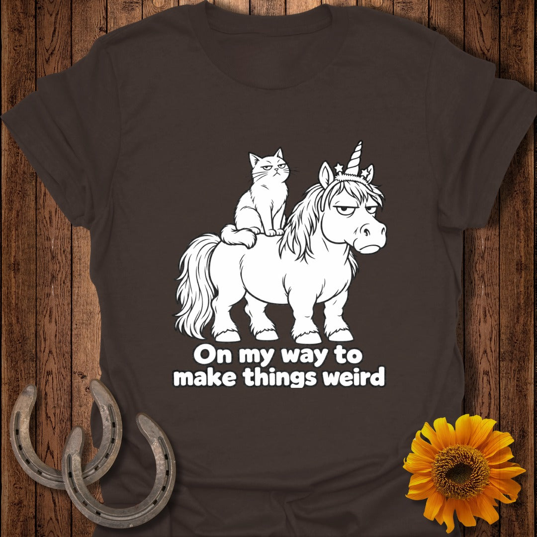 Brown t-shirt featuring a white graphic of a grumpy cat riding a grumpy unicorn, with the text "On my way to make things weird".