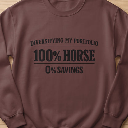 Brown sweatshirt with text: "Diversifying my portfolio 100% horse 0% savings".