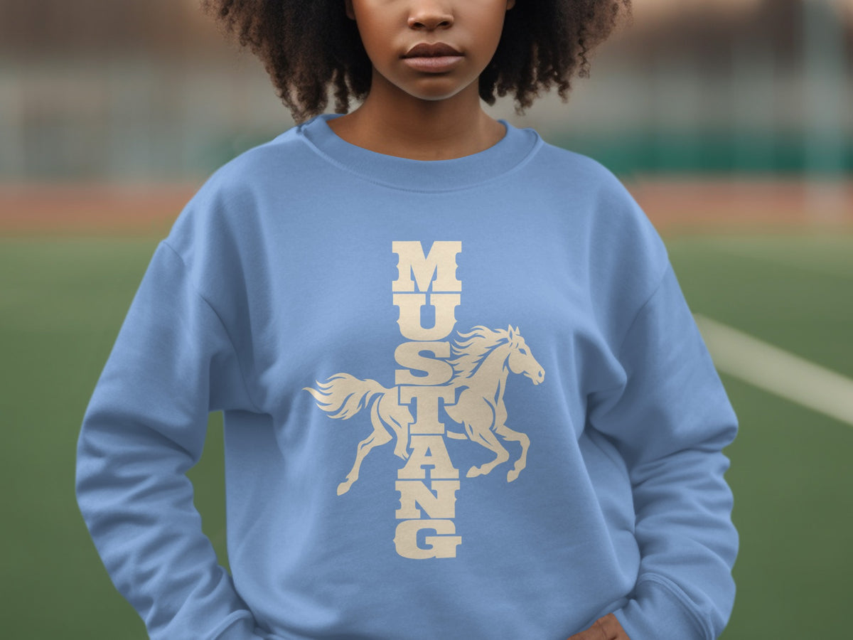 A person wearing a light blue crewneck sweatshirt with the word Mustang and a running horse graphic vertically across the chest.