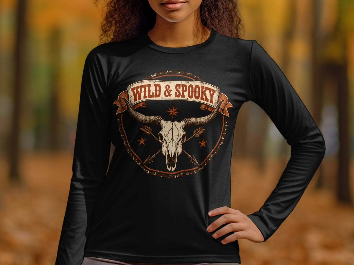 Black long-sleeve shirt with "Wild & Spooky" text above a bull skull and arrows graphic.